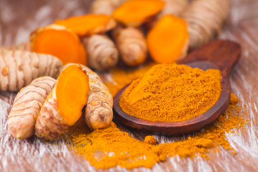 turmeric powder and roots, Asian origin plant containing curcumin has very powerful anti-inflammatory and antioxidant properties